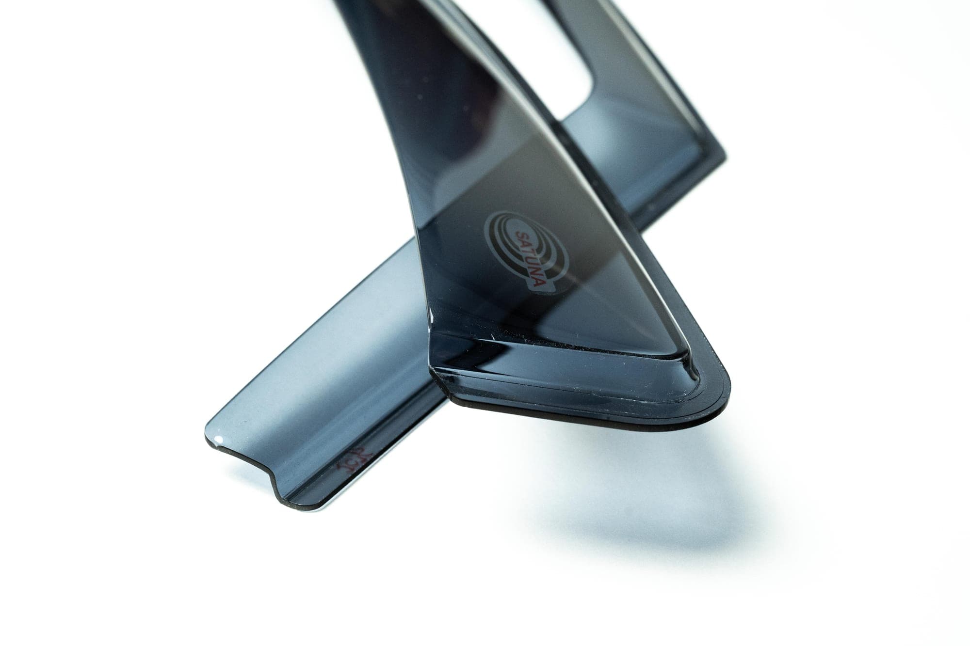 Pair of smoke-tinted SATUNA Classic wind deflectors on a white background, with the etched SATUNA mark visible