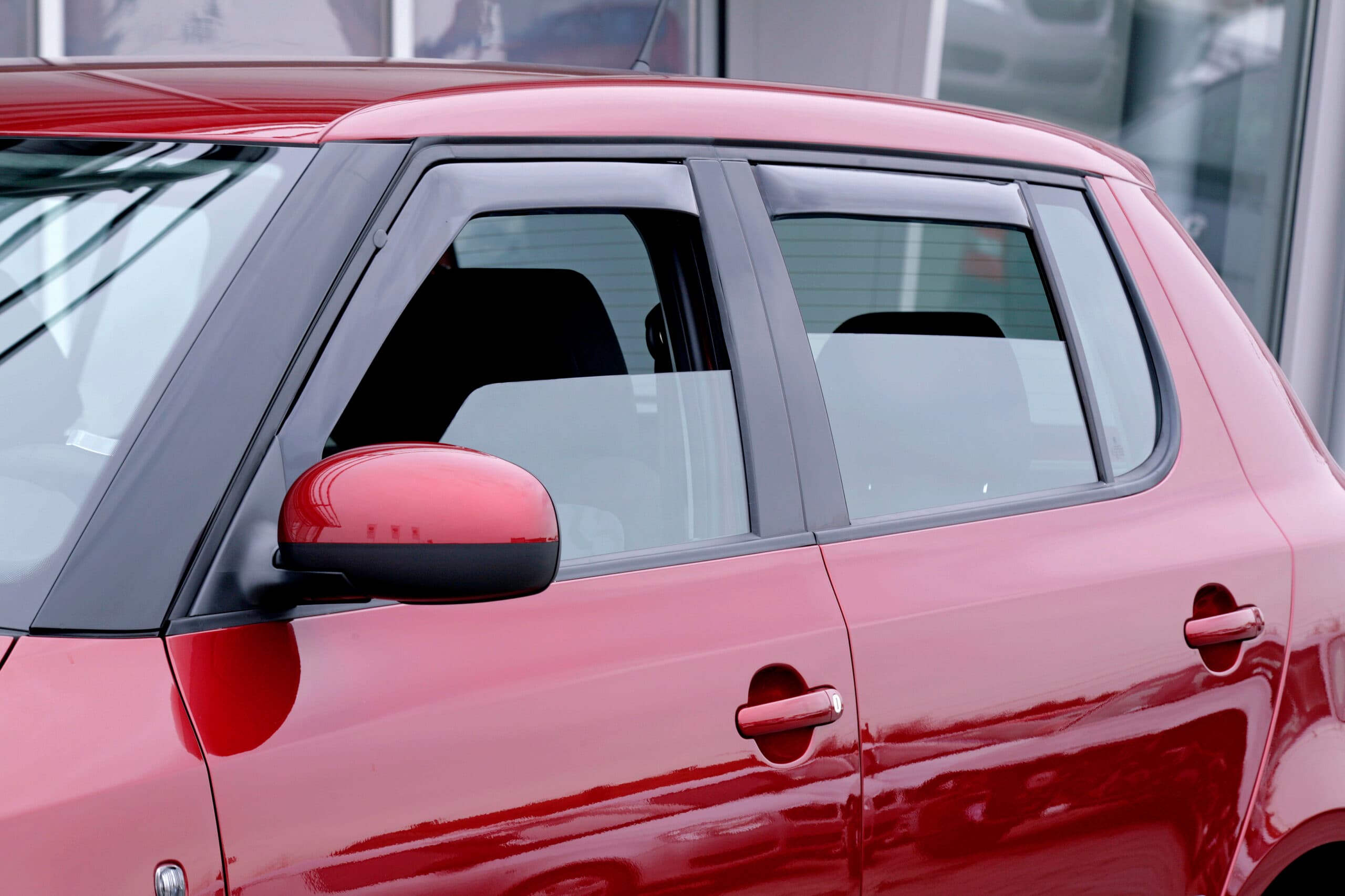 SATUNA wind deflector fitted to the front window of a red hatchback